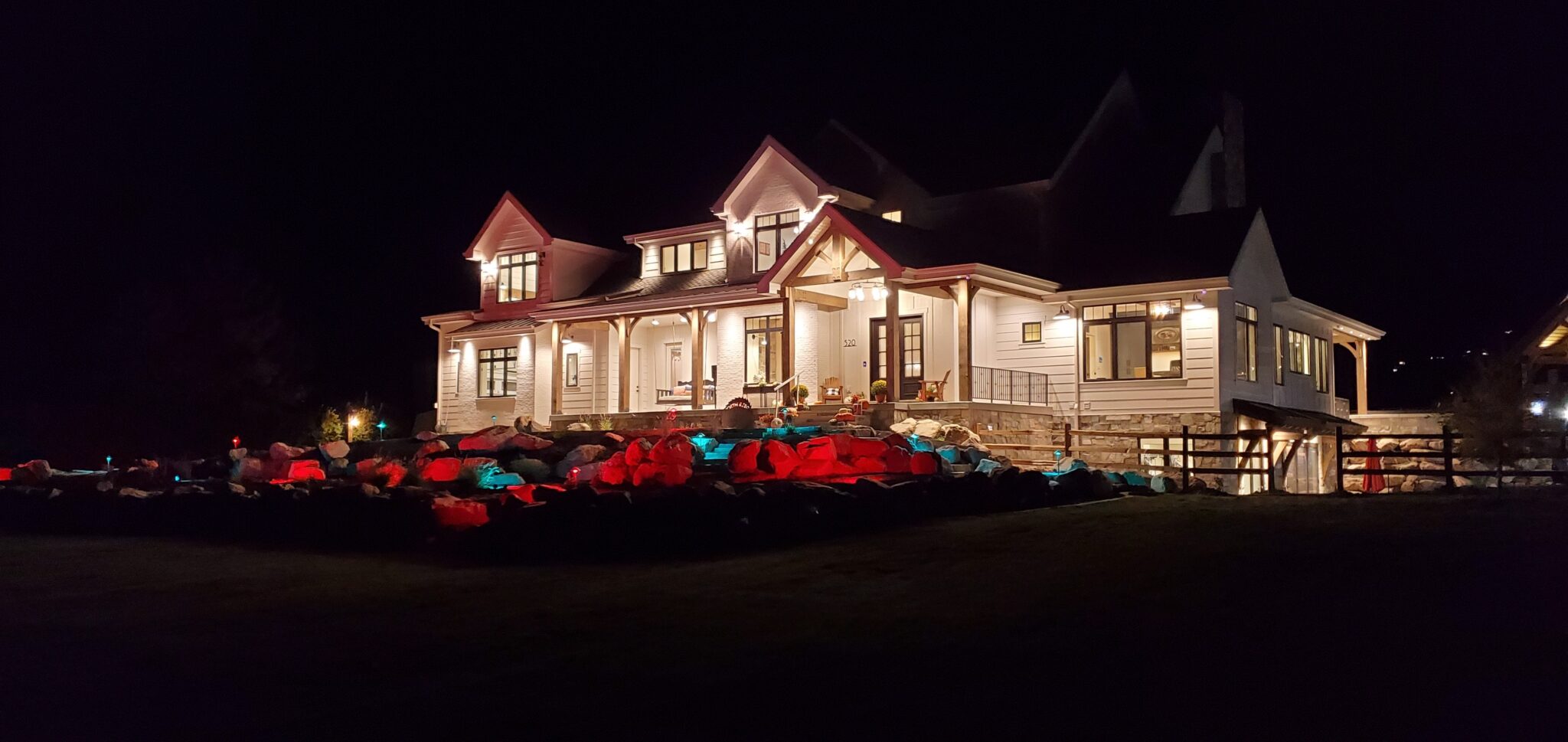 a home with red and green exterior landscape lighting for christmas